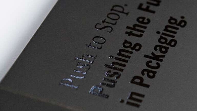 Schwarzer Karton mit schwarzer glänzender Schrift