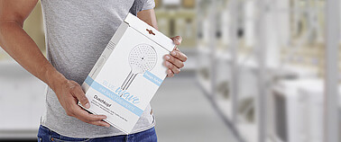 Mann hält Handbrause-Verpackung in der Hand