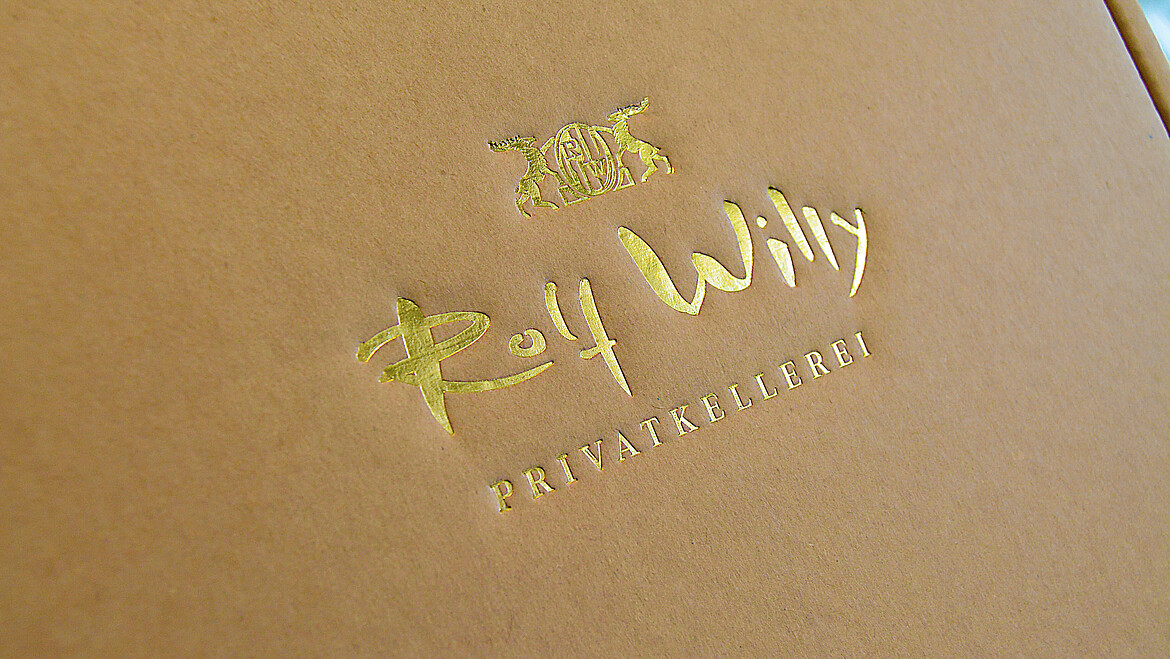 Heißfolienprägung eines Schriftzugs auf schwarzem Hintergrund