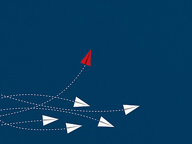 Papierflieger auf blauem Hintergrund